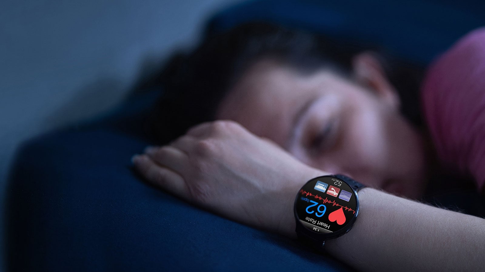 Schlafende Person, die eine Smartwatch trägt, welche während der Nacht die Herzfrequenz und Gesundheitsdaten überwacht.