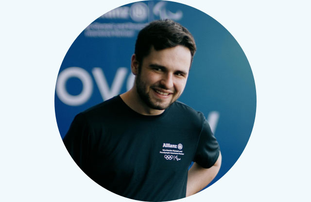 Andy "Kassio" Landais is wearing a MoveNow Camp shirt while smiling in the camera.