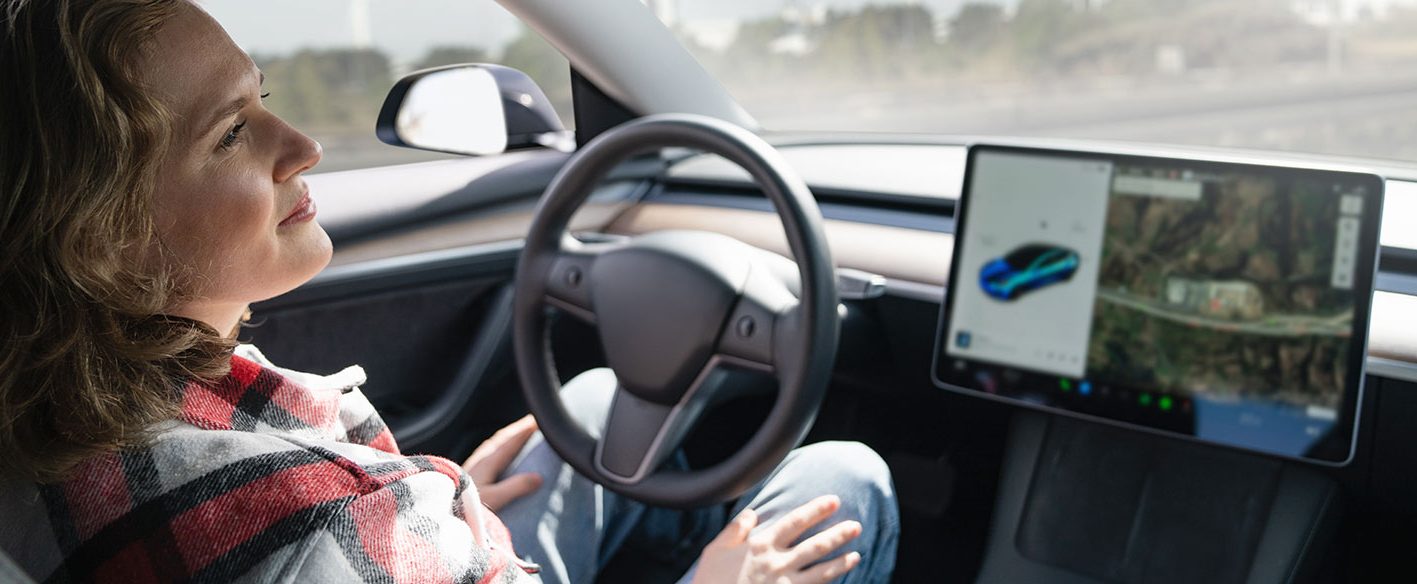 woman relaxed hands off the steering wheel while sitting in automated vehicle