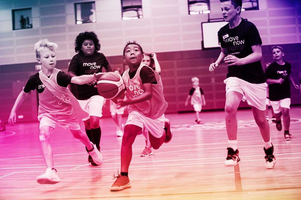 Children in sport action playing basketball, one of Allianz' MoveNow activity camps
