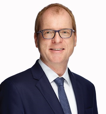 Carsten Quitter, Allianz Group Chief Investment Officer. He is wearing gray-framed glasses and smiling.