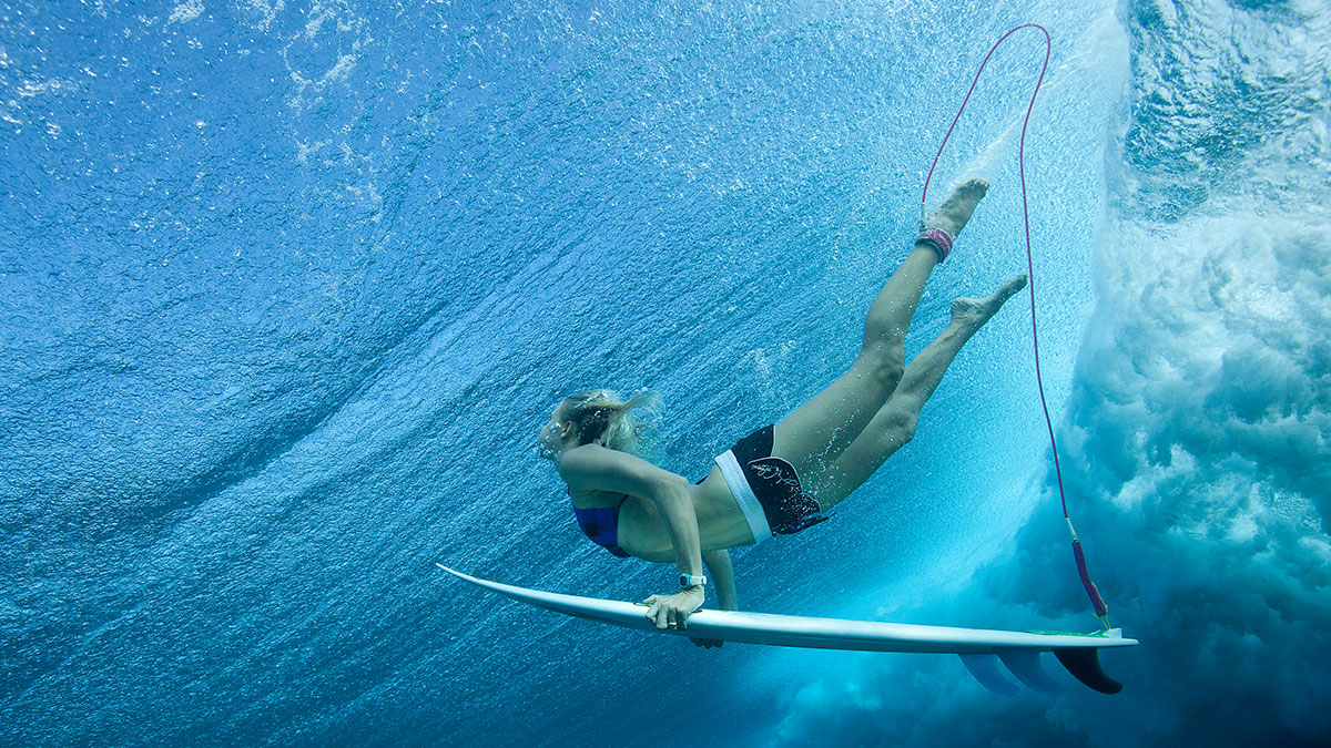 Surfing women with her board below water