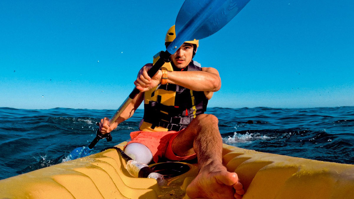Para-Sportler ohne rechtes Bein paddelt mit einem Kanu auf dem Meer