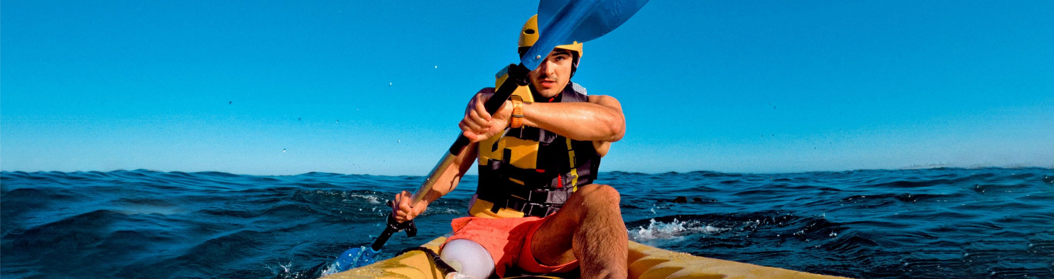 Para-Athlet ohne rechtes Bein paddelt mit einem Kanu auf dem Meer