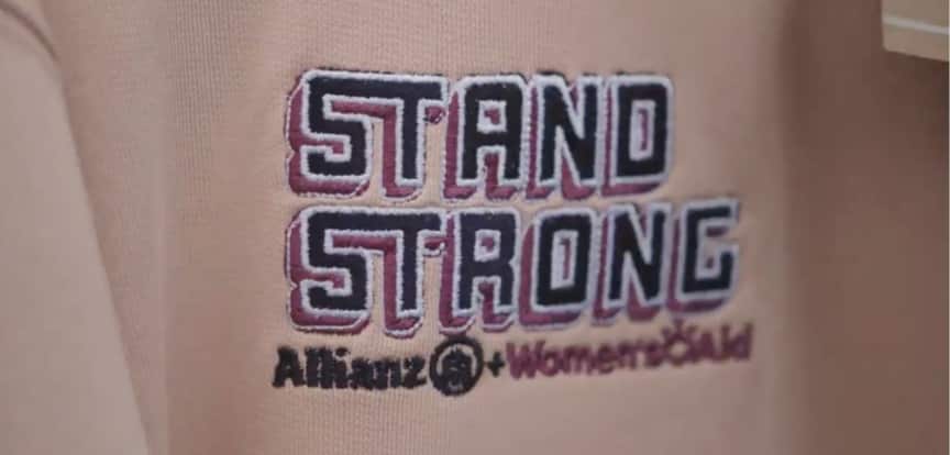 A t-shirt with the branding "stand strong" with Allianz plus womens aid