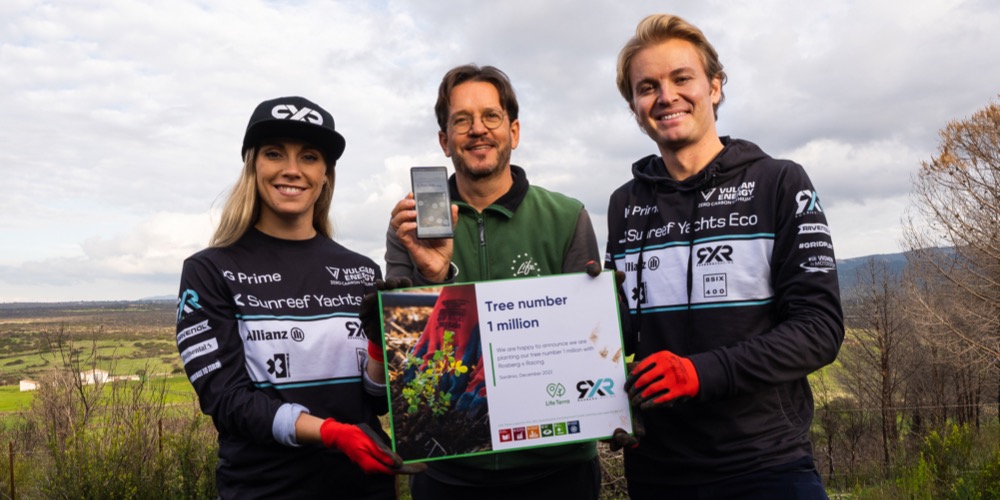 Extreme E professional Nico Rosberg holding in a team of three persons a plate that says we are happy to announce we are planting our tree number 1 million with Rosberg xRacing