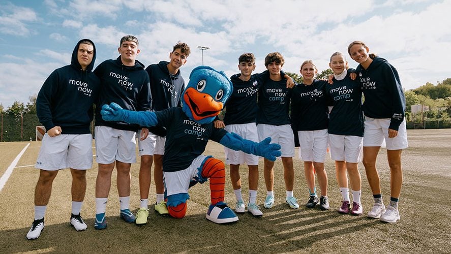 Group photo of all participants of the Global Edition MoveNow Camp together with a life-size figure of the Allianz eagle mascot