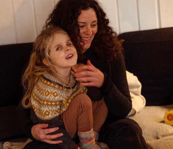 Woman with her blind daughter sitting happily on a couch
