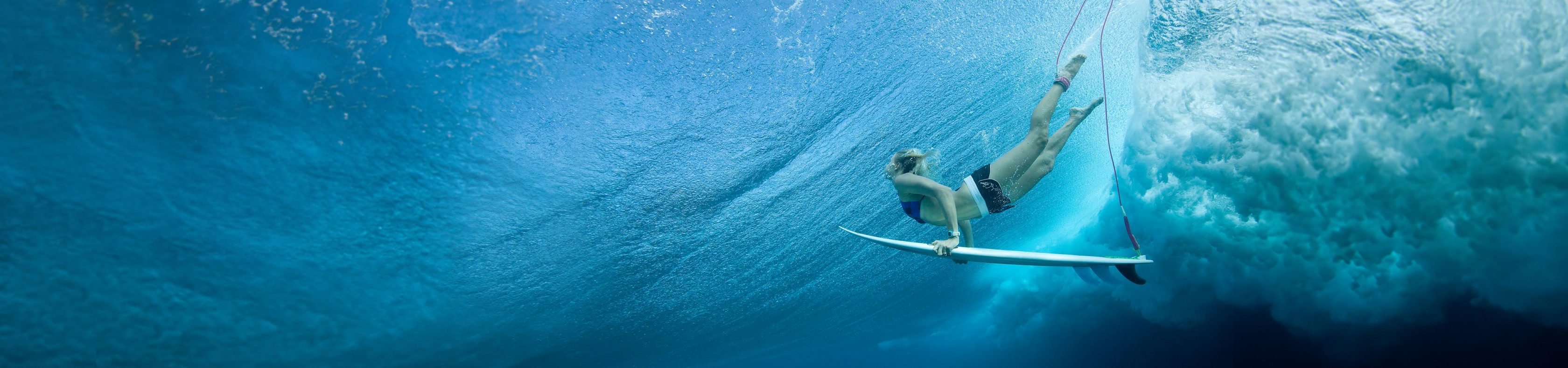 Surferin mit Surfboard unter Wasser
