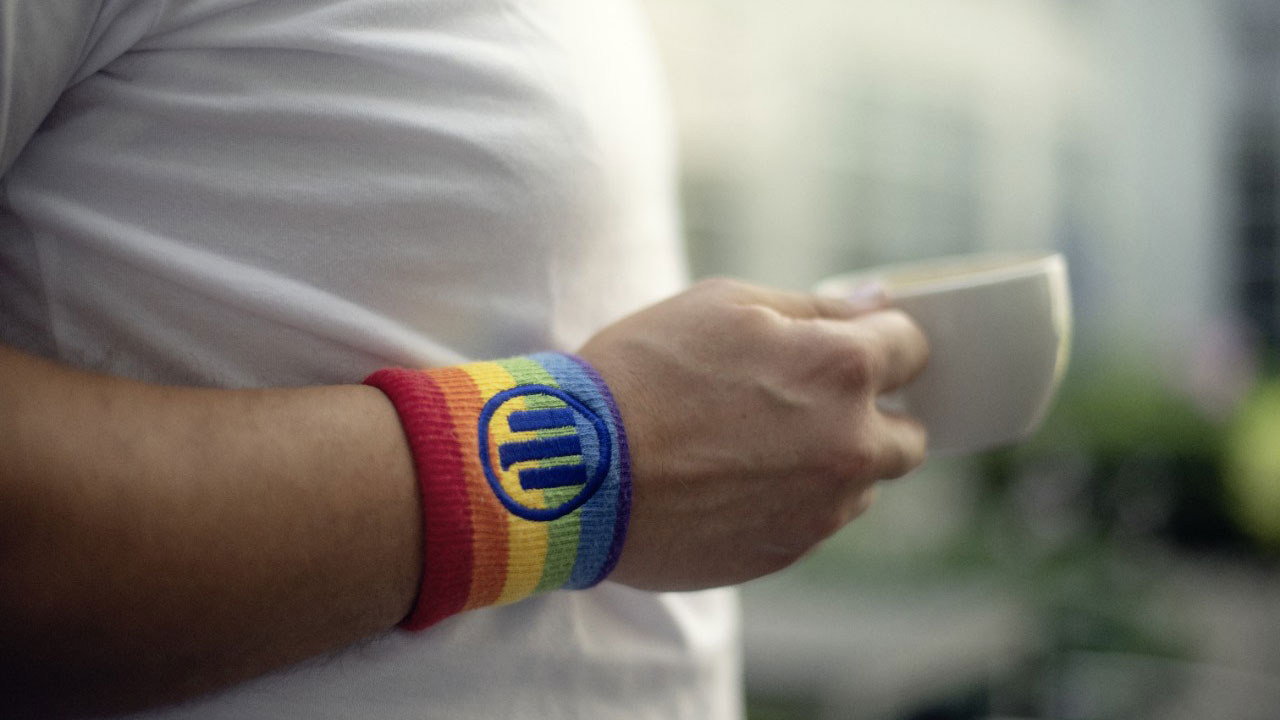 Detail von Arm mit regenbogenfarbenen Schweißband mit Allianz Logo an Arm