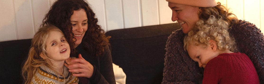 Woman with her blind daughter sitting happily on a couch