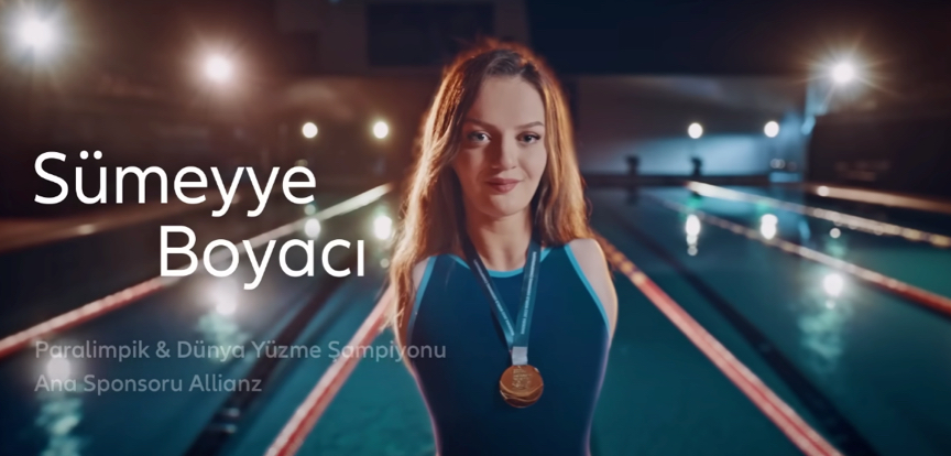 A Paralympic swimmer poses with a gold medal around her neck