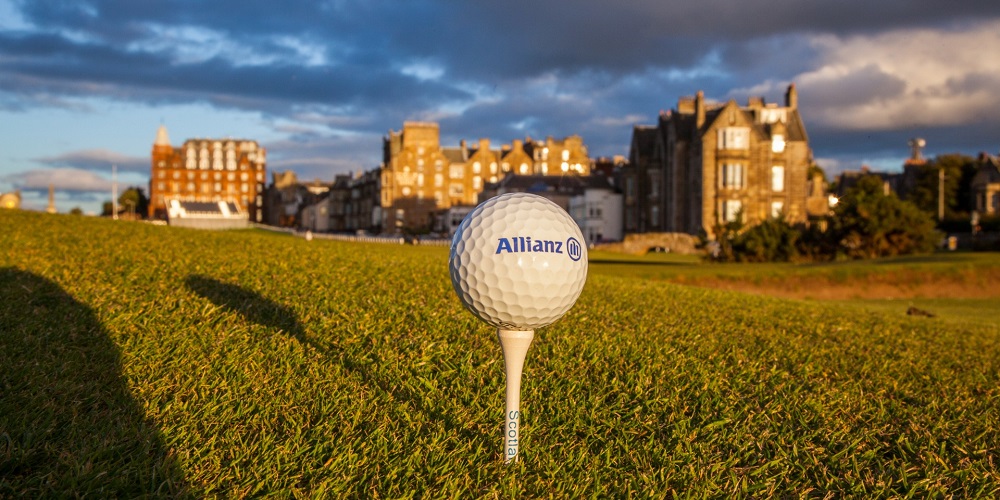 Golf ball in the foreground. Background: Traditional St. Andrews golf park buildings, Scotland