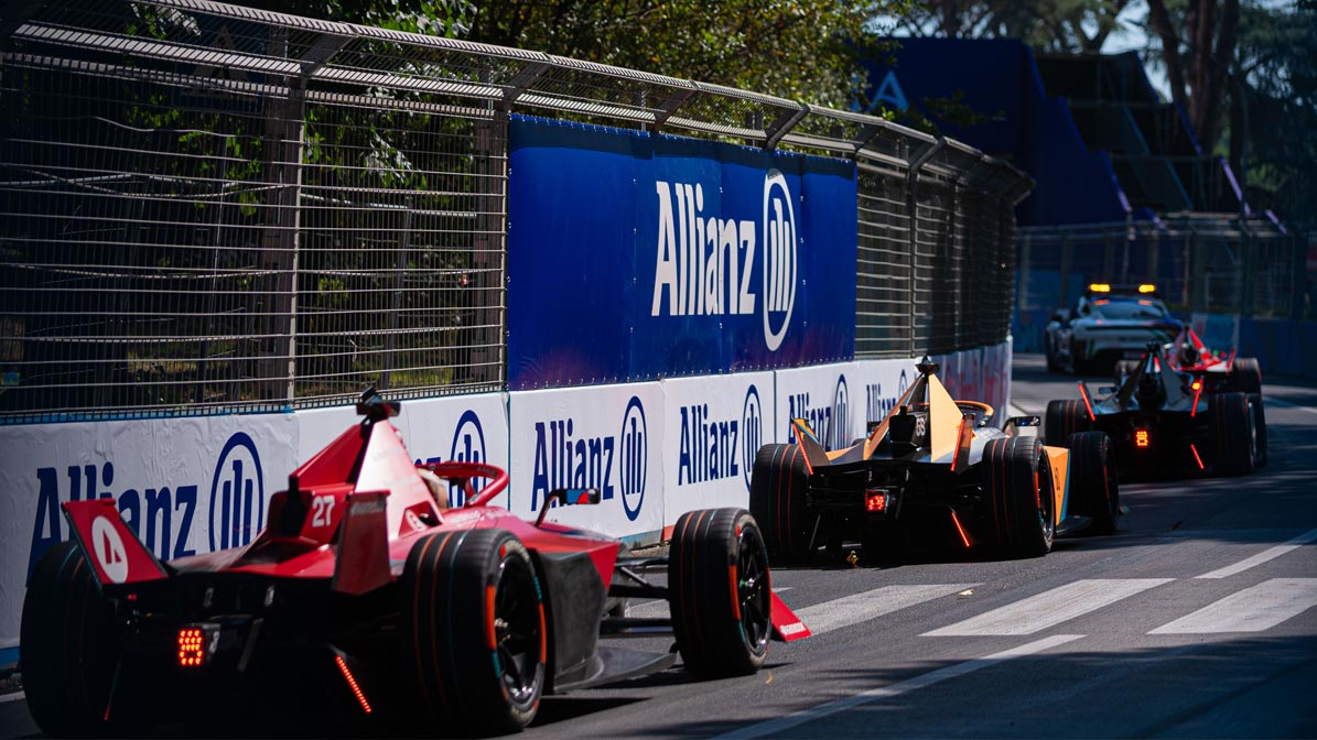 Formula-E race cars waiting in a row on the track for the start, Allianz advertising on the roadsides