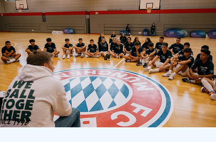 Basketball training participants together in a circle, listening to the former FC Bayern professional athlete Hamann