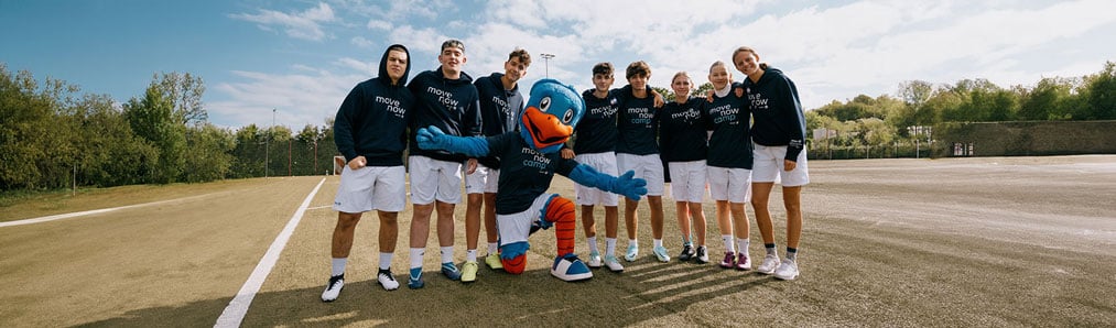 Group photo of all participants of the Global Edition MoveNow Camp together with a life-size figure of the Allianz eagle mascot