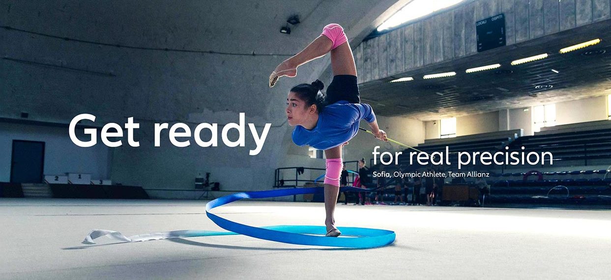 An Olympic gymnastics athlete is training in a sports hall. Headline saying: "Get ready for real precision. Sofia, Olympic Athlete, Team Allianz."