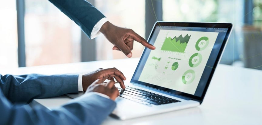 A hand points to a set of green data values on a laptop