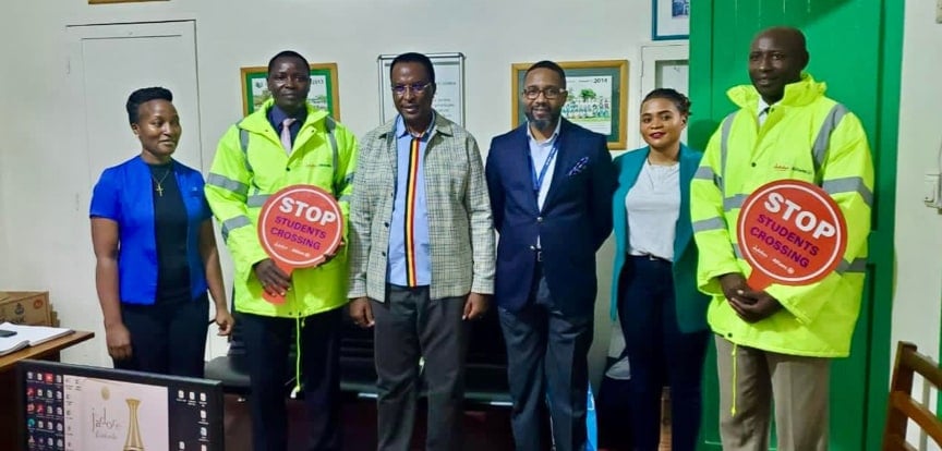 A group of Allianz Uganda employees post for a picture with traffic safety officers