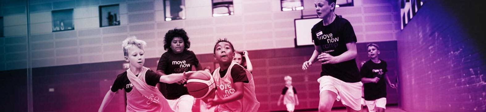 Children playing basketball, wearing t-shirts with movenow logo