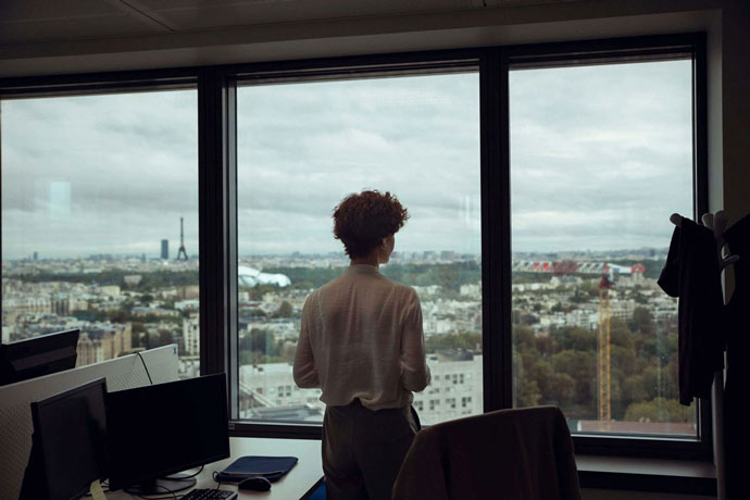 The photograph of an employee looking out through the office window