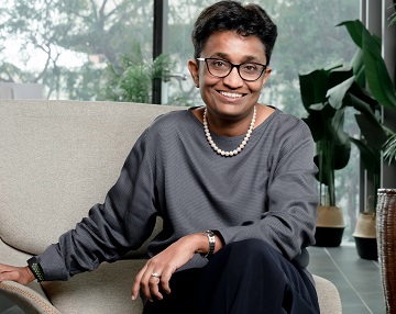 Anusha Tavaraja, Regional CEO, Allianz Asia Pacific, casually seated on a sofa and smiling at the camera.