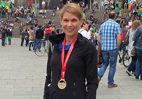Andrea Betello, AGCS Germany, in front of the Cologne Cathedral sporting her medal after finishing the “Rhein Energie Mararthon”.