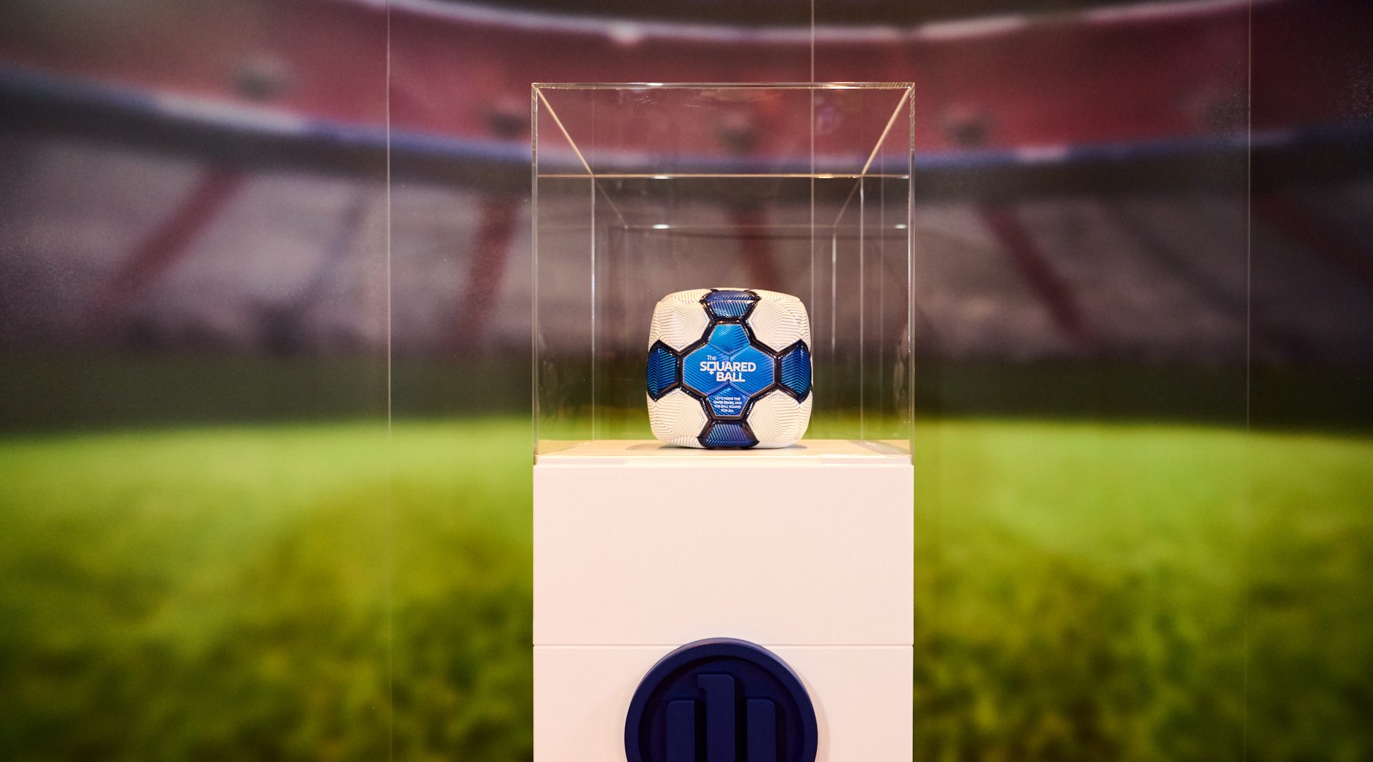 Close-up of the Squared Football model in a plexiglass cabinet showcase