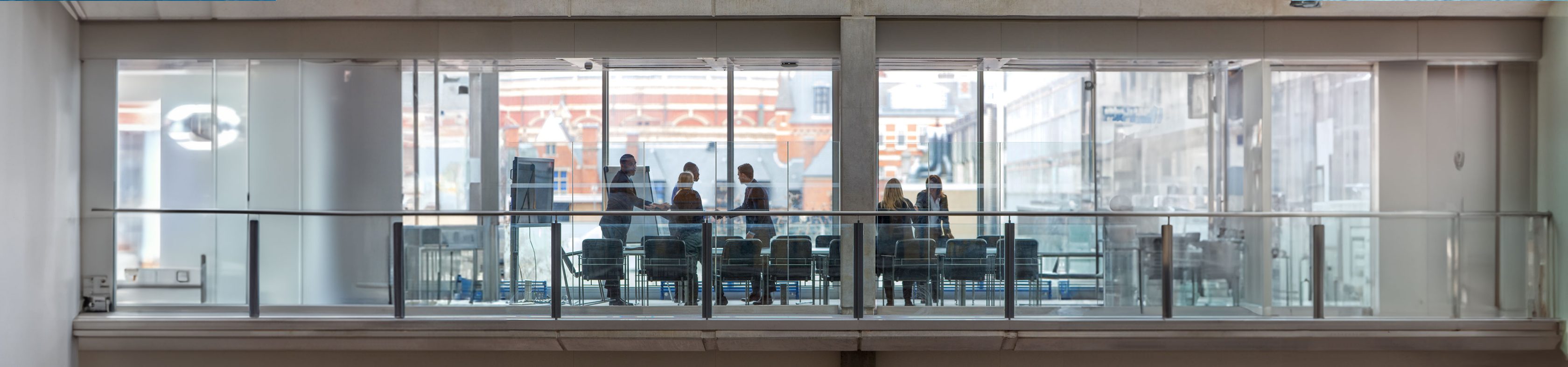 People during a conference in a glass room